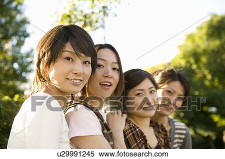 Stock Photography - Portrait of four women smiling. Fotosearch