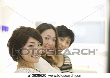 Stock Image - Portrait of three young women smiling. Fotosearch