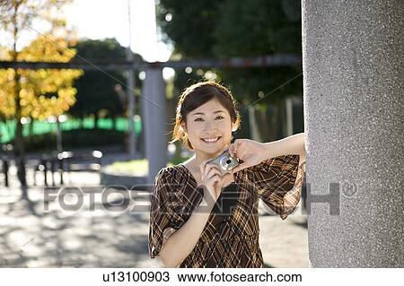Young woman holding digital camera View Large Photo Image Stock Image - Young woman holding digital camera. Fotosearch