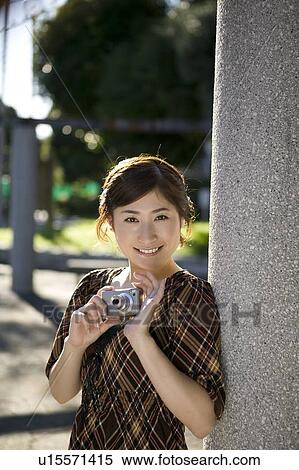 Young woman holding digital camera View Large Photo Image Stock Photography - Young woman holding digital camera. Fotosearch