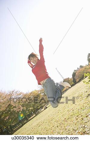 Young woman jumping View Large Photo Image Stock Image - Young woman jumping. Fotosearch