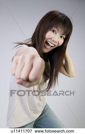 Stock Photo - Young woman punching. Fotosearch