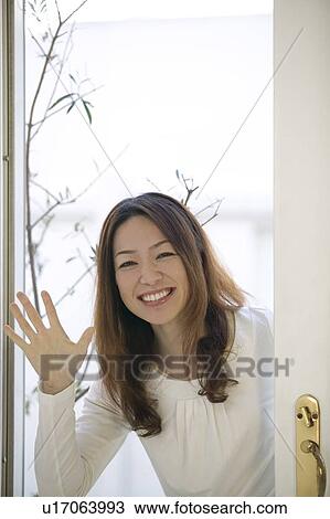 Stock Image - Young woman waving hand. Fotosearch