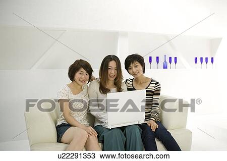 Stock Image - Young women using computer. Fotosearch