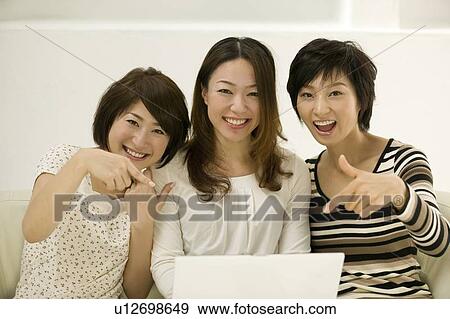 Stock Photo - Young women using computer. Fotosearch