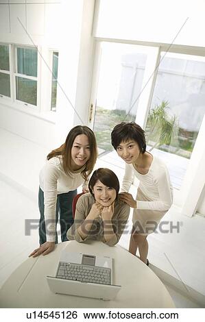 Stock Photograph - Young women using computer. Fotosearch