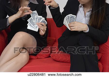 Stock Image - Two business women playing cards. Fotosearch