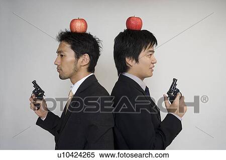 Two businessmen holding toy guns View Large Photo Image Stock Photography - Two businessmen holding toy guns. Fotosearch