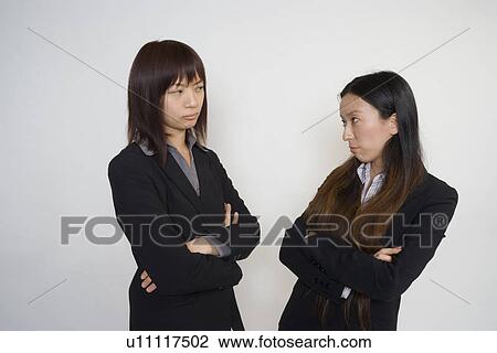 Stock Image - Two young businesswomen confronting. Fotosearch
