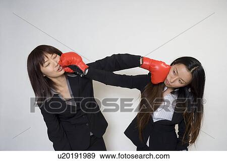 Stock Photo - Two young businesswomen fighting. Fotosearch