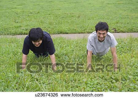 Two young men doing push-ups View Large Photo Image Stock Photograph - Two young men doing push-ups. Fotosearch