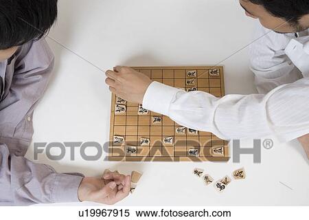 Stock Photography - Two young men playing Japanese chess. Fotosearch