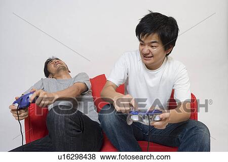Two young men playing video game View Large Photo Image Stock Photo - Two young men playing video game. Fotosearch