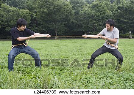 Stock Photo - Two young men pulling rope. Fotosearch
