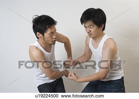 Stock Image - Two young men showing muscle each other. Fotosearch