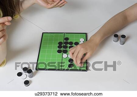 Two young women playing Othello game View Large Photo Image Stock Image - Two young women playing Othello game. Fotosearch