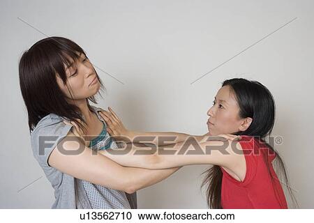Two young women pushing each other View Large Photo Image Stock Image - Two young women pushing each other. Fotosearch