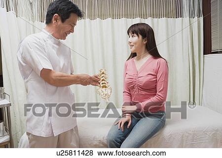 Chiropractic doctor consulting with patient View Large Photo Image Stock Photo - Chiropractic doctor consulting with patient. Fotosearch
