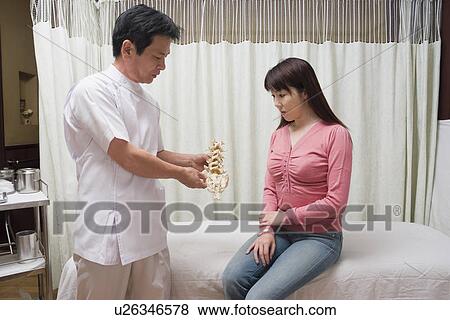 Chiropractic doctor consulting with patient View Large Photo Image Stock Photo - Chiropractic doctor consulting with patient. Fotosearch
