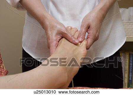 Therapist massaging patient's foot View Large Photo Image Stock Image - Therapist massaging patient's foot. Fotosearch
