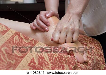 Therapist massaging patient's foot View Large Photo Image Stock Photograph - Therapist massaging patient's foot. Fotosearch