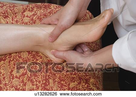 Therapist massaging patient's foot View Large Photo Image Stock Photograph - Therapist massaging patient's foot. Fotosearch