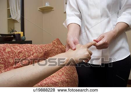 Therapist massaging patient's hand View Large Photo Image Stock Photo - Therapist massaging patient's hand. Fotosearch