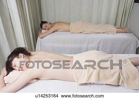 Picture - Two women receiving acupuncture treatment. Fotosearch