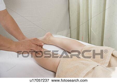 Stock Photo - Woman receiving acupuncture treatment. Fotosearch