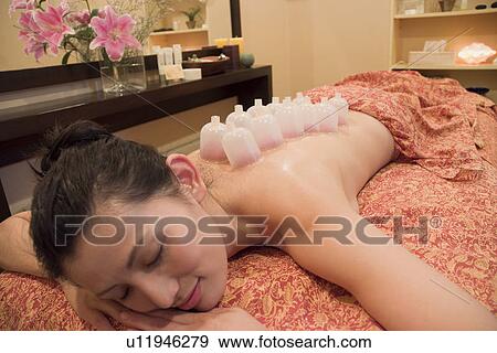 Stock Photo - Young woman receiving cupping massage. Fotosearch