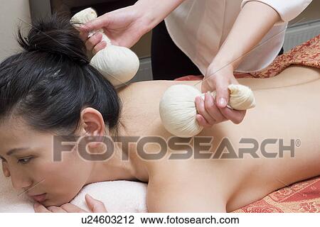 Young woman receiving herbal ball massage View Large Photo Image Stock Image - Young woman receiving herbal ball massage. Fotosearch