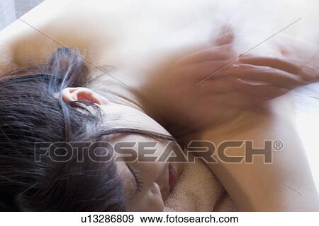Stock Photo - Young woman receiving massage, blurred motion. Fotosearch