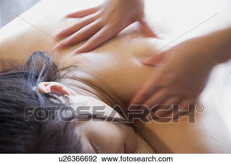 Stock Image - Young woman receiving massage. Fotosearch