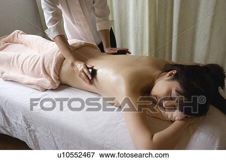 Young woman receiving stone massage View Large Photo Image Stock Photo - Young woman receiving stone massage. Fotosearch