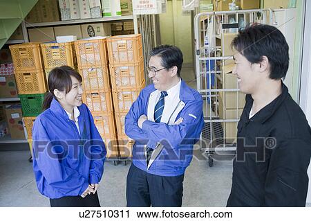 Colleagues talking in warehouse View Large Photo Image Stock Image - Colleagues talking in warehouse. Fotosearch