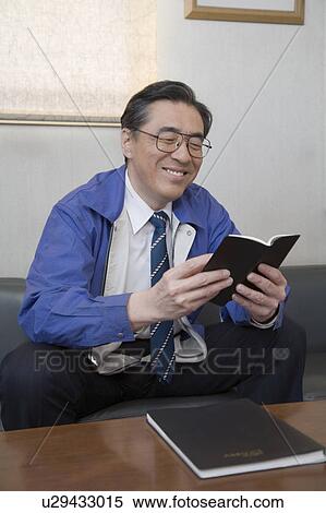 Stock Photography - Mature man looking at notebook. Fotosearch