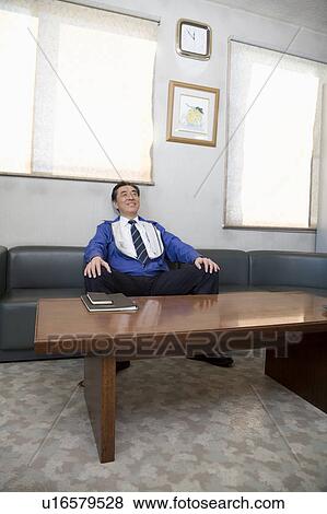 Stock Photo - Mature man sitting in sofa. Fotosearch