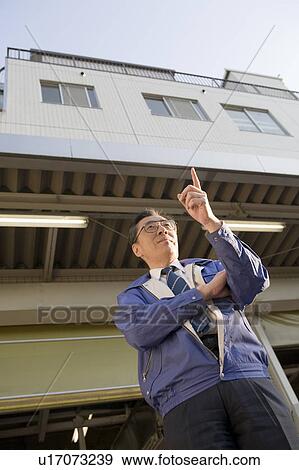 Stock Photo - Mature man standing in front of warehouse. Fotosearch