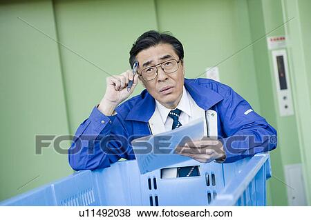 Stock Photo - Mature warehouse staff confused. Fotosearch
