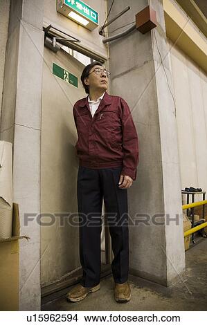 Senior worker standing in warehouse View Large Photo Image Picture - Senior worker standing in warehouse. Fotosearch