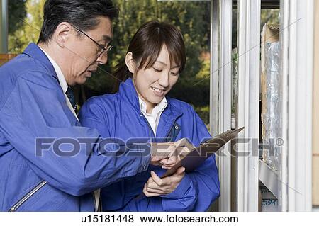 Stock Photo - Warehouse workers checking sheet. Fotosearch