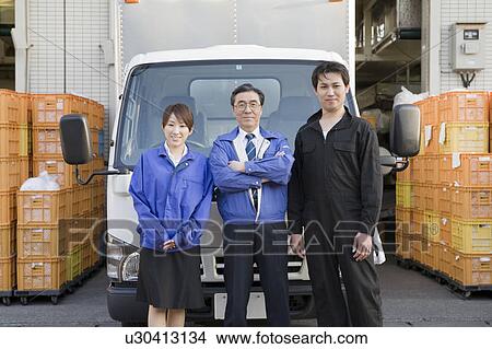 Picture - Warehouse workers standing in front of truck. Fotosearch