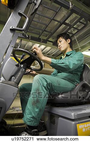 Stock Image - Young man using forklift. Fotosearch
