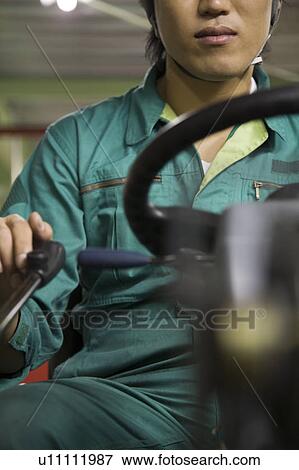 Stock Photo - Young man using forklift. Fotosearch