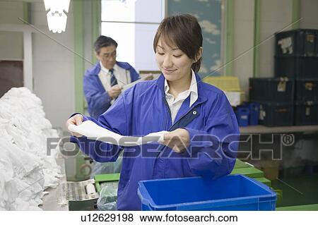 Young woman checking towels View Large Photo Image Stock Photo - Young woman checking towels. Fotosearch