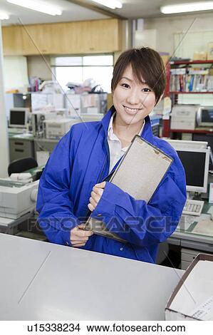 Picture - Young woman holding clipboard. Fotosearch