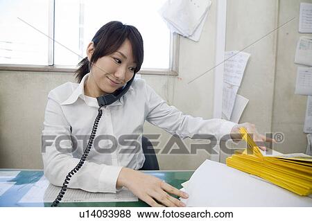 Stock Photo - Young woman talking over telephone. Fotosearch