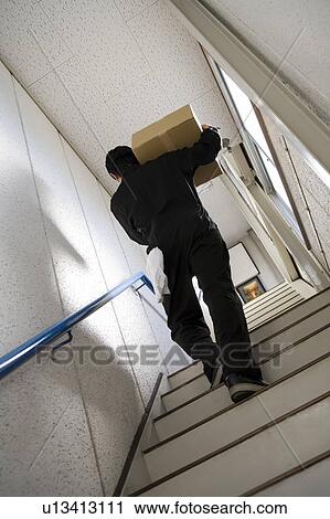 Young worker carrying box View Large Photo Image Stock Image - Young worker carrying box. Fotosearch