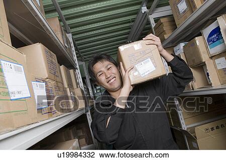 Young worker carrying box View Large Photo Image Stock Image - Young worker carrying box. Fotosearch