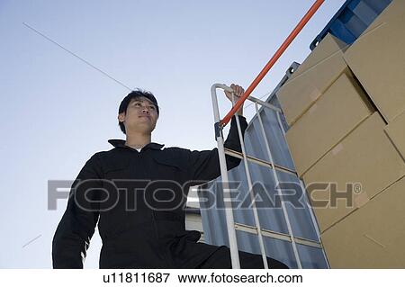 Young worker carrying boxes View Large Photo Image Stock Photo - Young worker carrying boxes. Fotosearch